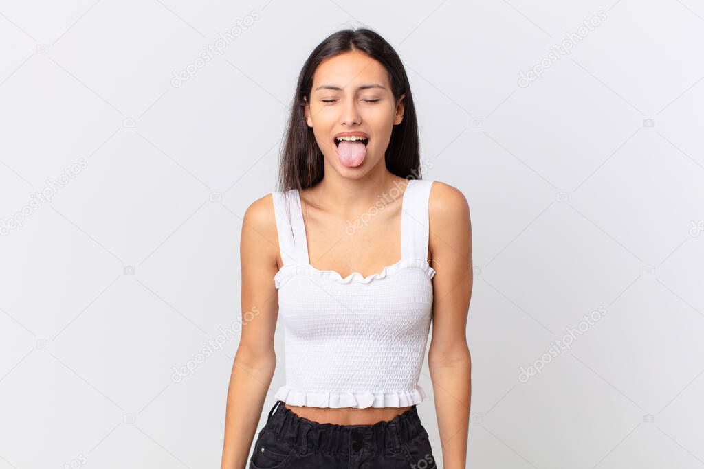 hispanic pretty woman with cheerful and rebellious attitude, joking and sticking tongue out