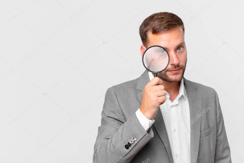 handsome businessman finfing with a magnifying glass