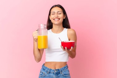 hispanic pretty woman with a breakfast bowl with flakes and orange juice