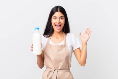 İspanyol aşçı kadın kendini mutlu ve şaşkın hissediyor. İnanılmaz bir şey ve elinde bir süt şişesi var.