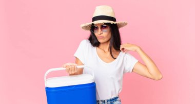 İspanyol güzeli kadın kibirli, başarılı, pozitif ve gururlu görünüyor. Portatif buzdolabıyla.