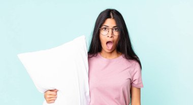 Güzel İspanyol kadın şok olmuş ya da şaşırmış görünüyor ve yastıklı pijama giyiyor.