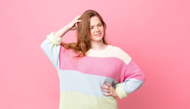 Güzel kızıl saçlı kadın şaşkın ve kafası karışık, kaşınan kafa