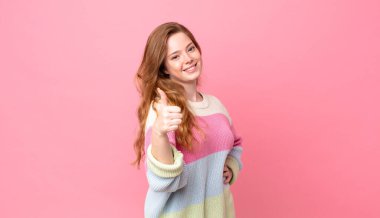 Güzel kızıl saçlı kadın gururlu, olumlu gülümsüyor.