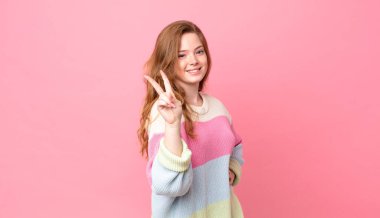 Güzel kızıl saçlı kadın gülümsüyor ve arkadaş canlısı görünüyor.