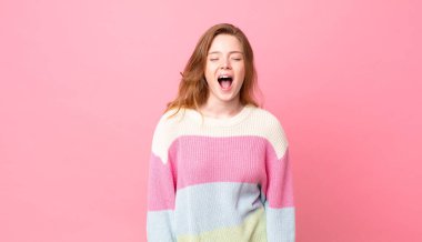 Güzel kızıl saçlı kadın agresif bağırıyor, çok kızgın görünüyor.