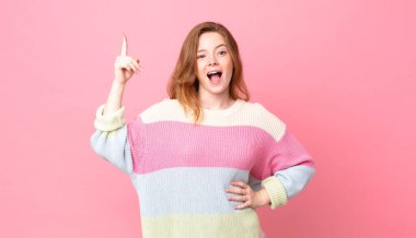 Güzel kızıl saçlı kadın bir fikri fark ettikten sonra mutlu ve heyecanlı bir dahi gibi hissediyor.