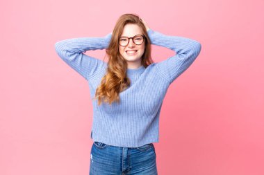 Güzel kızıl saçlı kadın stresli, endişeli ya da korkmuş, elleri başının üstünde