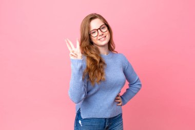 Güzel kızıl saçlı kadın gülümsüyor ve arkadaş canlısı görünüyor.