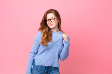 Güzel kızıl saçlı kadın kibirli, başarılı, pozitif ve gururlu görünüyor.