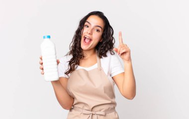 İspanyol güzel şef kadın bir fikri fark ettikten ve elinde bir süt şişesi tutduktan sonra kendini mutlu ve heyecanlı bir dahi gibi hissediyor.