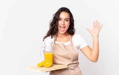 İspanyol güzel şef kadın kendini mutlu ve şaşkın hissediyor. İnanılmaz bir şey ve elinde portakal suyu var.