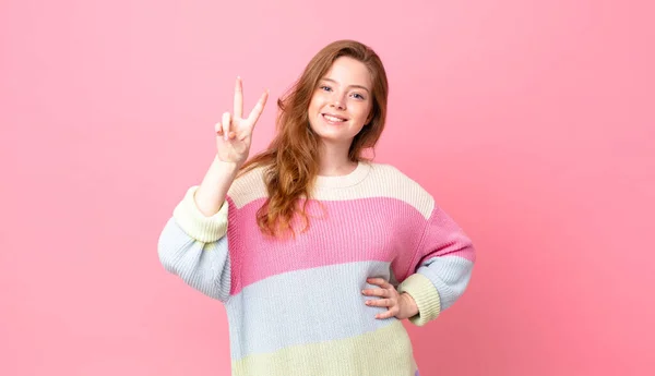 Bonita Mulher Cabeça Vermelha Sorrindo Olhando Feliz Gesticulando Vitória Paz — Fotografia de Stock