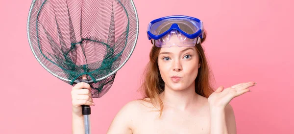 红头发的女人对护目镜和渔网感到困惑和困惑 — 图库照片