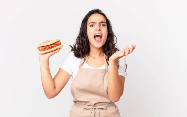 Latynoska Ładna Kucharka Wyglądająca Zdesperowaną Sfrustrowaną Zestresowaną Trzymającą Hot Doga — Zdjęcie stockowe