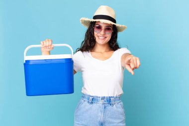 Güzel İspanyol kadın kamerayı işaret ederek seni portatif bir buzdolabı tutarak seçiyor.