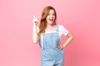 Kızıl saçlı güzel bir kadın bir fikri fark ettikten sonra mutlu ve heyecanlı bir dahi gibi hissediyor.