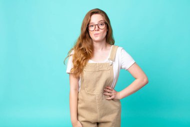 Güzel kızıl saçlı kadın kafası karışmış ve şaşkın görünüyor.