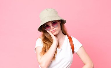 Kızıl saçlı, güzel bir kadın turist. Sıkılmış, hayal kırıklığına uğramış ve uykulu.