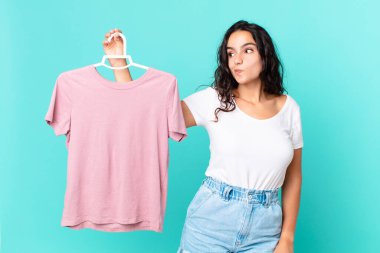 İspanyol güzel kadın omuz silkiyor, kafası karışık ve bir kumaş seçmekte kararsız.