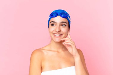 İspanyol güzel yüzücü kadın mutlu bir şekilde gülümsüyor ve hayal kuruyor ya da gözlüklerle şüpheye düşüyor.