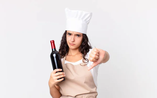 ヒスパニックかわいい料理人の女性が十字架を感じ親指を立ててワインボトルを持ち — ストック写真