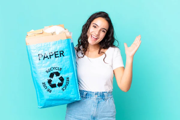 ヒスパニックかわいい女性は信じられないほどの何かに幸せと驚きリサイクル紙の袋を持って — ストック写真