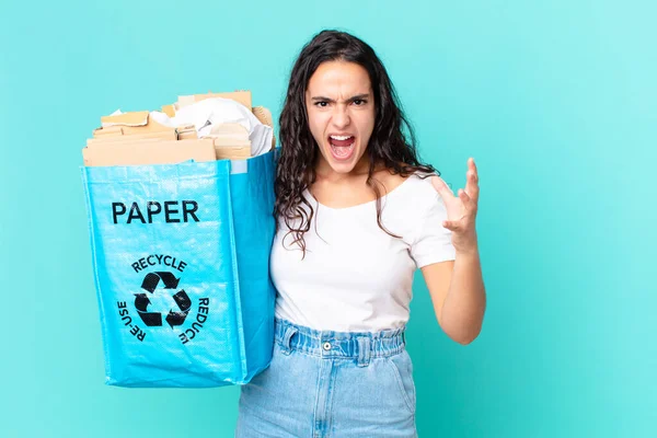 ヒスパニックかわいい女性は怒っていらいらしていらいらしてリサイクル紙の袋を持っています — ストック写真
