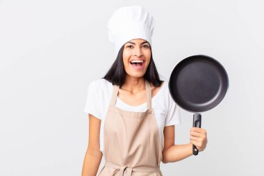 İspanyol güzel şef kadın elinde bir tava tutuyor.