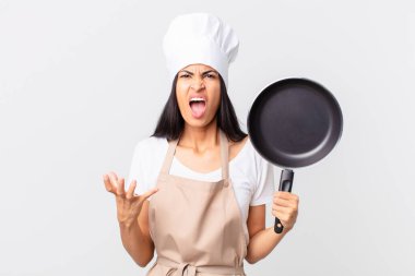 İspanyol güzel şef kadın elinde bir tava tutuyor.