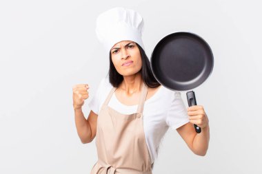 İspanyol güzel şef kadın elinde bir tava tutuyor.