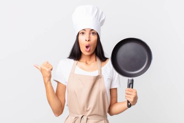 İspanyol güzel şef kadın elinde bir tava tutuyor.