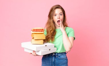 Güzel kızıl saçlı kadın elinde hazır yemek kutuları tutuyor.