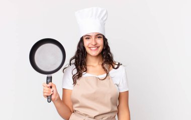 İspanyol güzel şef kadın elinde bir tava tutuyor.
