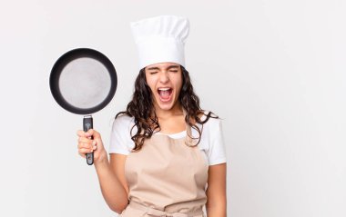 İspanyol güzel şef kadın elinde bir tava tutuyor.