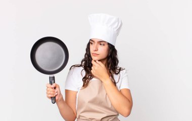 İspanyol güzel şef kadın elinde bir tava tutuyor.