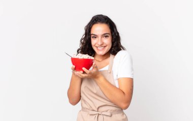 İspanyol güzel aşçı kadın elinde sütlü kahvaltı kasesi tutuyor.