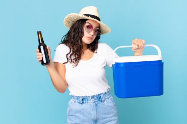 Portatif buzdolabı ve bira şişesi olan İspanyol güzeli bir kadın.