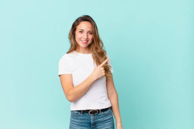 Güzel bir kadın neşeyle gülümsüyor, mutlu hissediyor ve bir tarafı işaret ediyor.