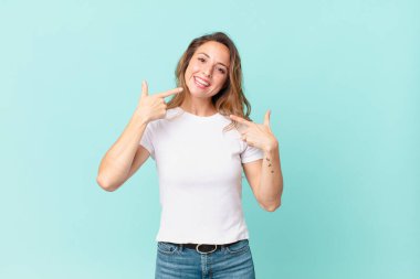 Kendine güvenen güzel bir kadın kendi gülüşünü işaret ediyor.