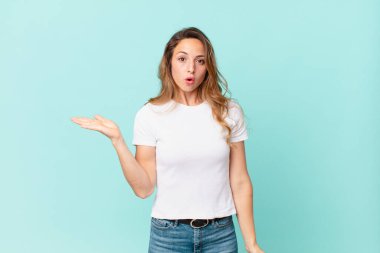 Güzel bir kadın şaşırmış ve şok olmuş görünüyor, çenesi düşmüş bir nesne tutuyor.