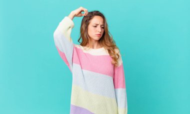 Güzel kadın şaşkın ve kafası karışmış hissediyor, başını kaşıyor.
