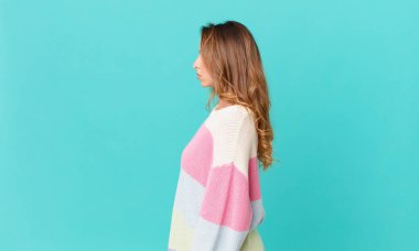 Güzel bir kadın profil görünümünde düşünüyor, hayal ediyor ya da hayal kuruyor.