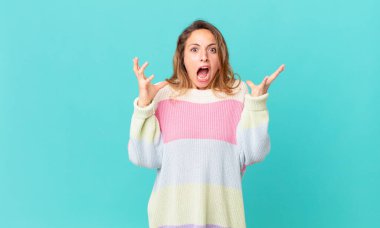 Güzel bir kadın ellerini havaya kaldırıp çığlık atıyor.