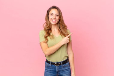 Güzel bir kadın neşeyle gülümsüyor, mutlu hissediyor ve bir tarafı işaret ediyor.