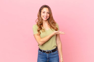 Güzel bir kadın neşeyle gülümser, mutlu hisseder ve bir konsept gösterir.