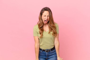 Güzel kadın agresif bir şekilde bağırıyor, çok kızgın görünüyor.