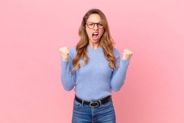 Güzel bir kadın sinirli bir ifadeyle agresif bir şekilde bağırıyor.