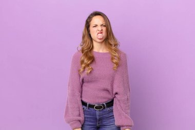 Güzel bir kadın tiksinti ve tedirginlik duyar ve dilini dışarı çıkarır.