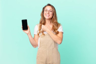 Güzel bir kadın kendini mutlu hisseder ve bir meydan okumayla yüzleşir ya da kutlama yapar ve akıllı telefon tutar.